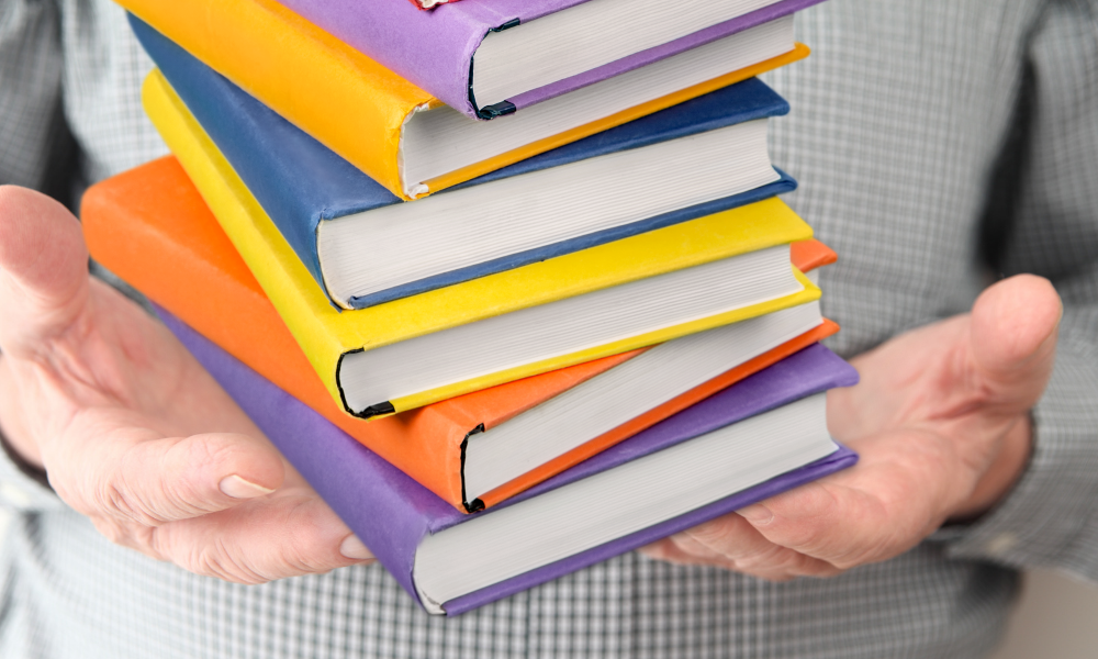 Mains encombrés par une pile de livre