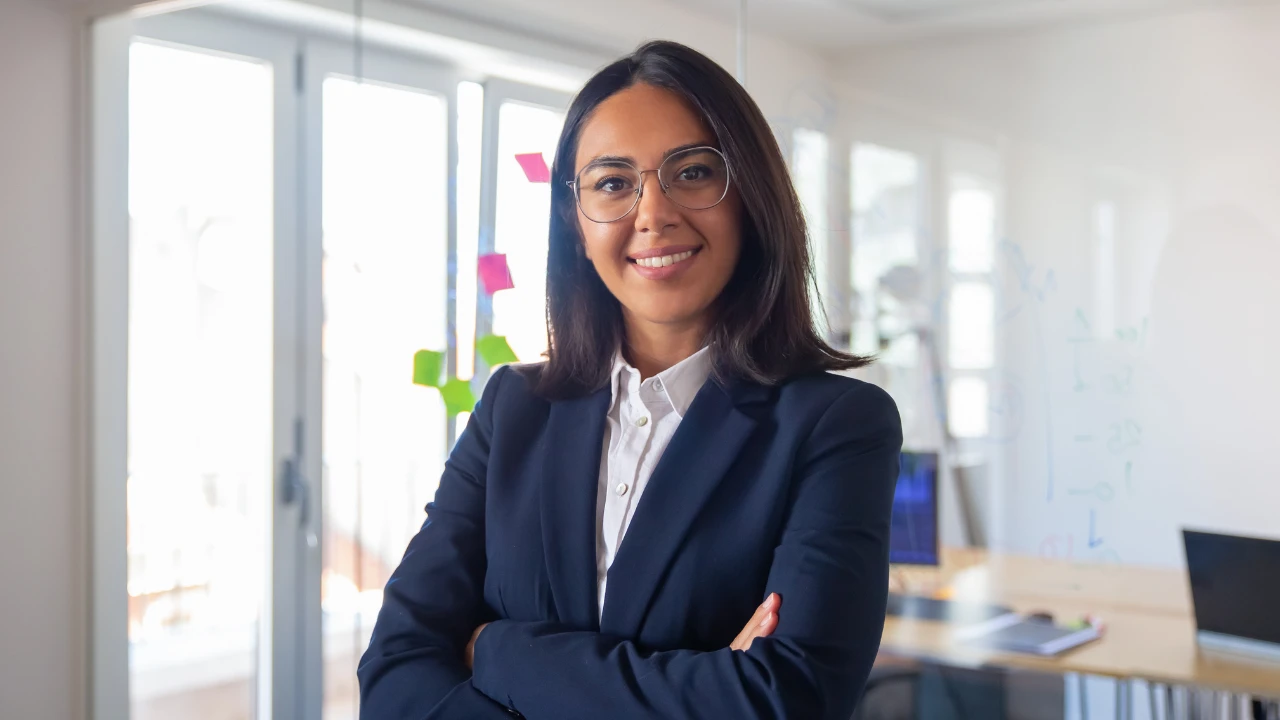 Femme d'affaire bras croisés avec un sourire qui inspire la confiance en soi