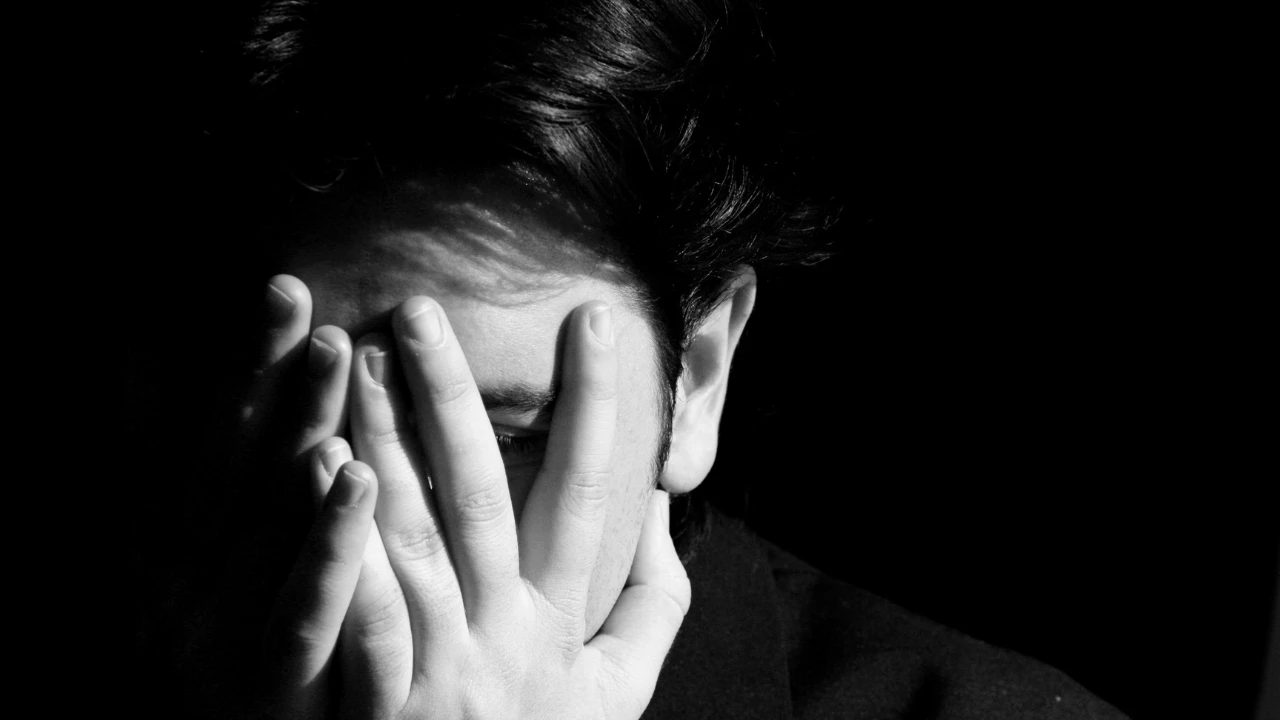 Personne qui ressent de la honte en se mettant les mains sur le visage. Image sombre