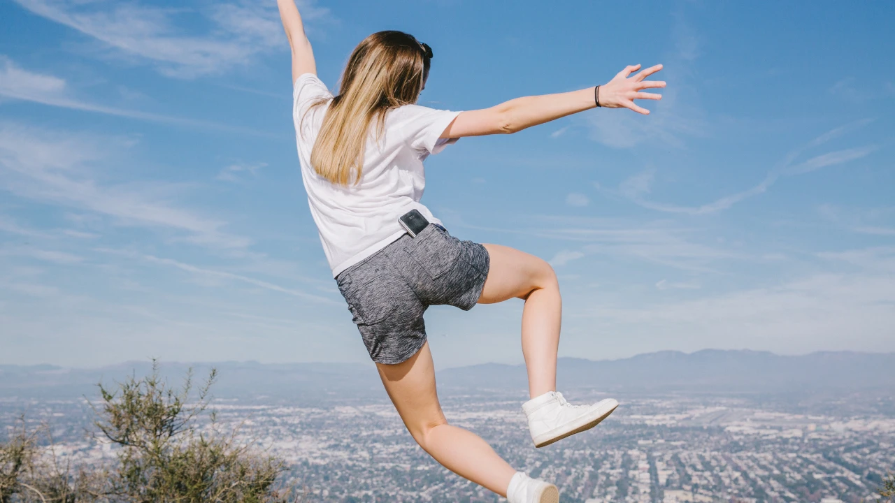 Fille qui saute de joie de dos