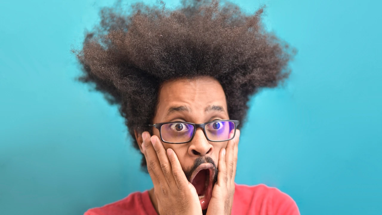 Un homme aux cheveux en pétard qui est surpris