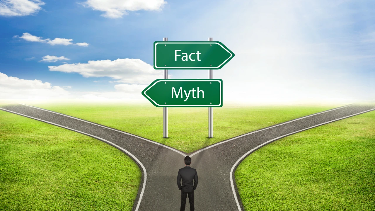 Homme d'affaires de dos face à un panneau "myth" et "faits"