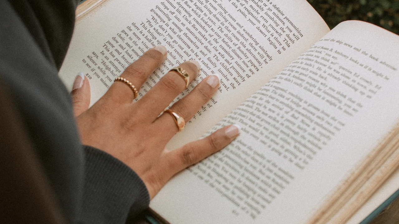 Un livre avec une main dessus représentant une personne en train de lire